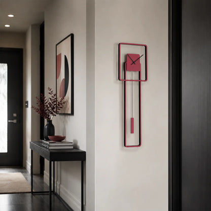 Reloj de pared con marco rojo y caja interior rectangular, pesa roja visible