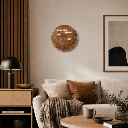 Runde LED-Wanduhr mit braunem Zifferblatt und leuchtender Wortanzeige an der Wand