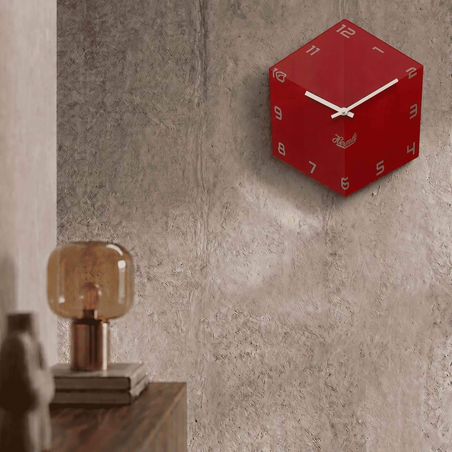 Reloj de pared redondo rojo de acrílico en la pared con manecillas blancas y logo de Hermle