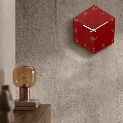Reloj de pared redondo rojo de acrílico en la pared con manecillas blancas y logo de Hermle