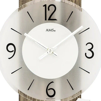 Wanduhr-Detail: weißes Zifferblatt mit Ams.-Logo, großen schwarzen Zahlen und Zeigern