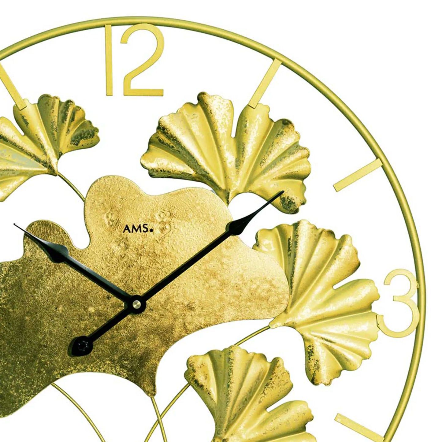 Nahaufnahme Wanduhr: goldfarbenes Blattmotiv, schwarze Zeiger, arabische Ziffern auf Rahmen