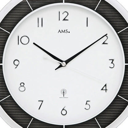 Großansicht Wanduhr: weißes Zifferblatt mit AMS, schwarzen Zeigern und Funksymbol