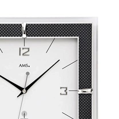 Nahaufnahme Funk-Wanduhr: Zeiger und Ziffern im schwarzen Carbonrahmen