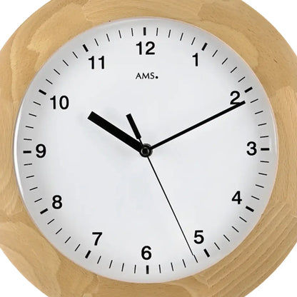 Nahaufnahme: runde Wanduhr mit weißem Zifferblatt, hellem Holzrand und schwarzem Zeigerwerk