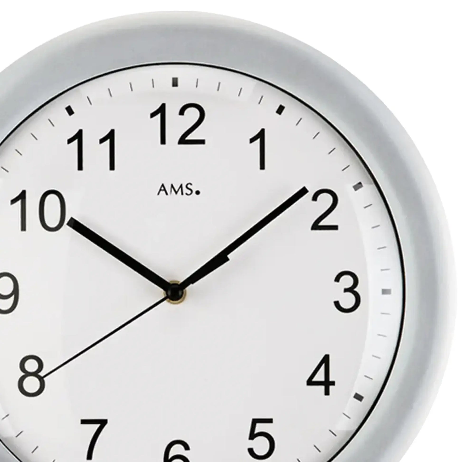 Nahaufnahme der Wanduhr: weißes Zifferblatt, schwarze Zahlen, schwarze Zeiger, silberner Rand