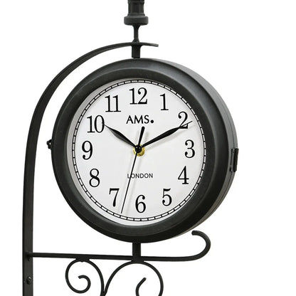 Rundes schwarzes Ziffernblatt der Wanduhr mit AMS-Logo und Zeigern, Mineralglas