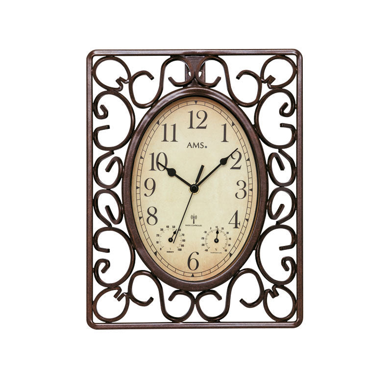 Antik väggklocka med oval urtavla och dekorerad metallram, krämfärgad bakgrund
