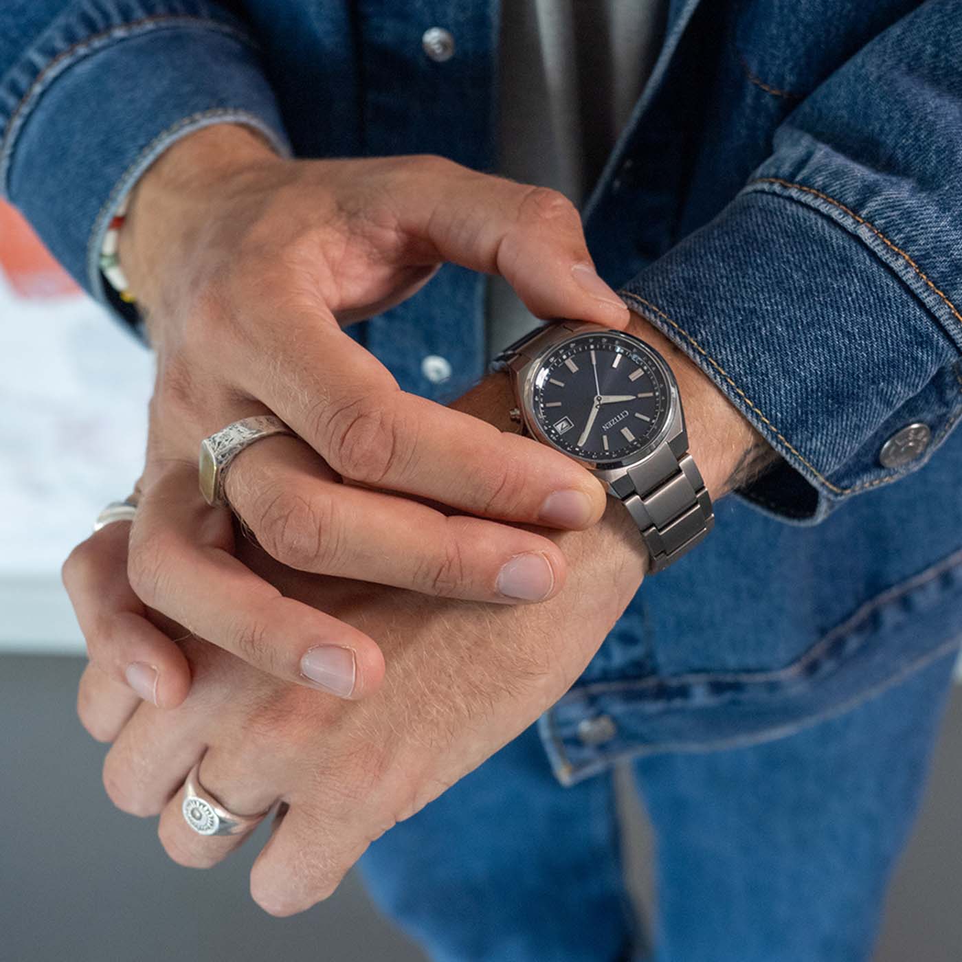 Citizen Armbanduhr am Handgelenk in Jeans, rundes blaues Zifferblatt