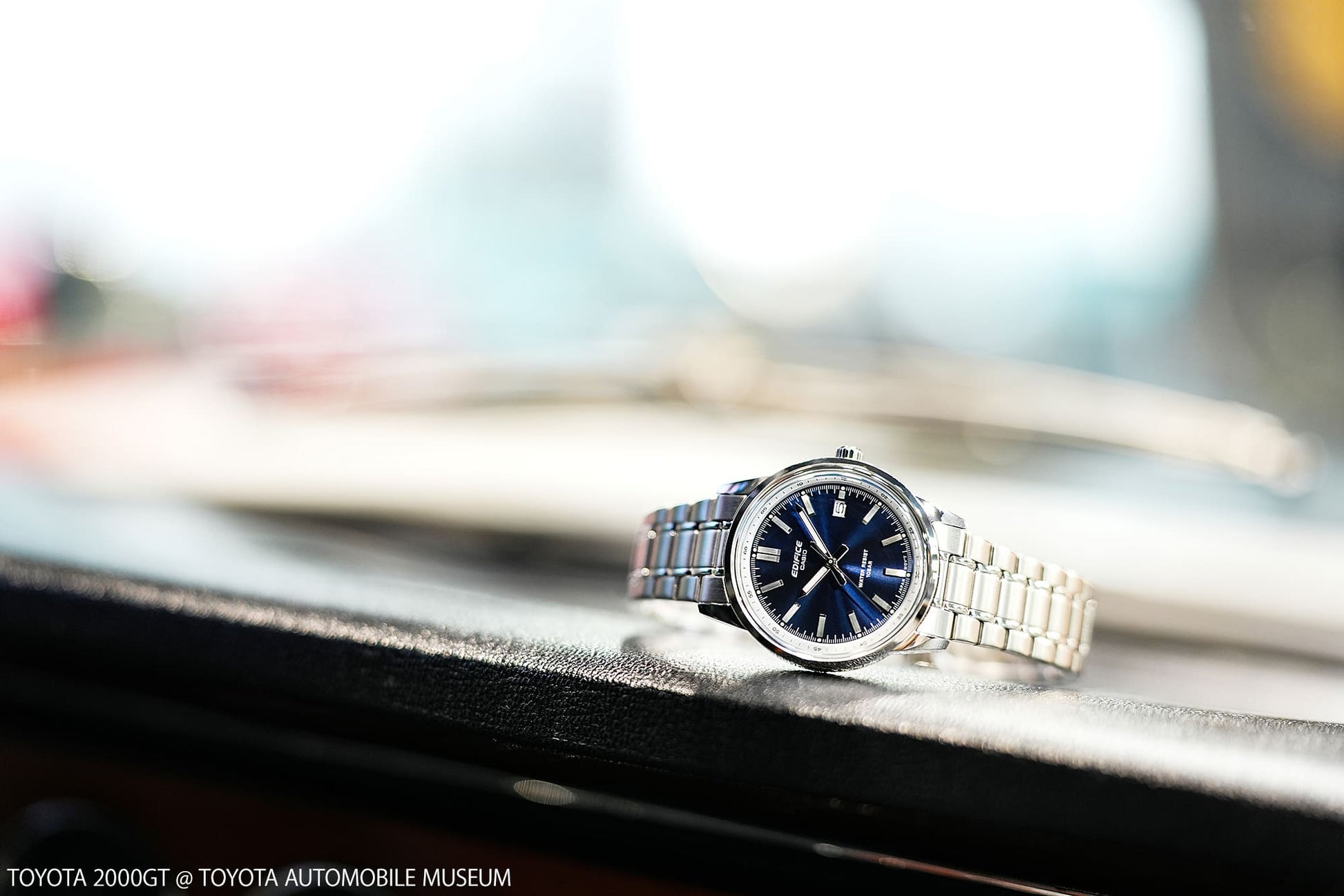 Herrenarmbanduhr seitlich auf dunklem Untergrund, blaues Zifferblatt
