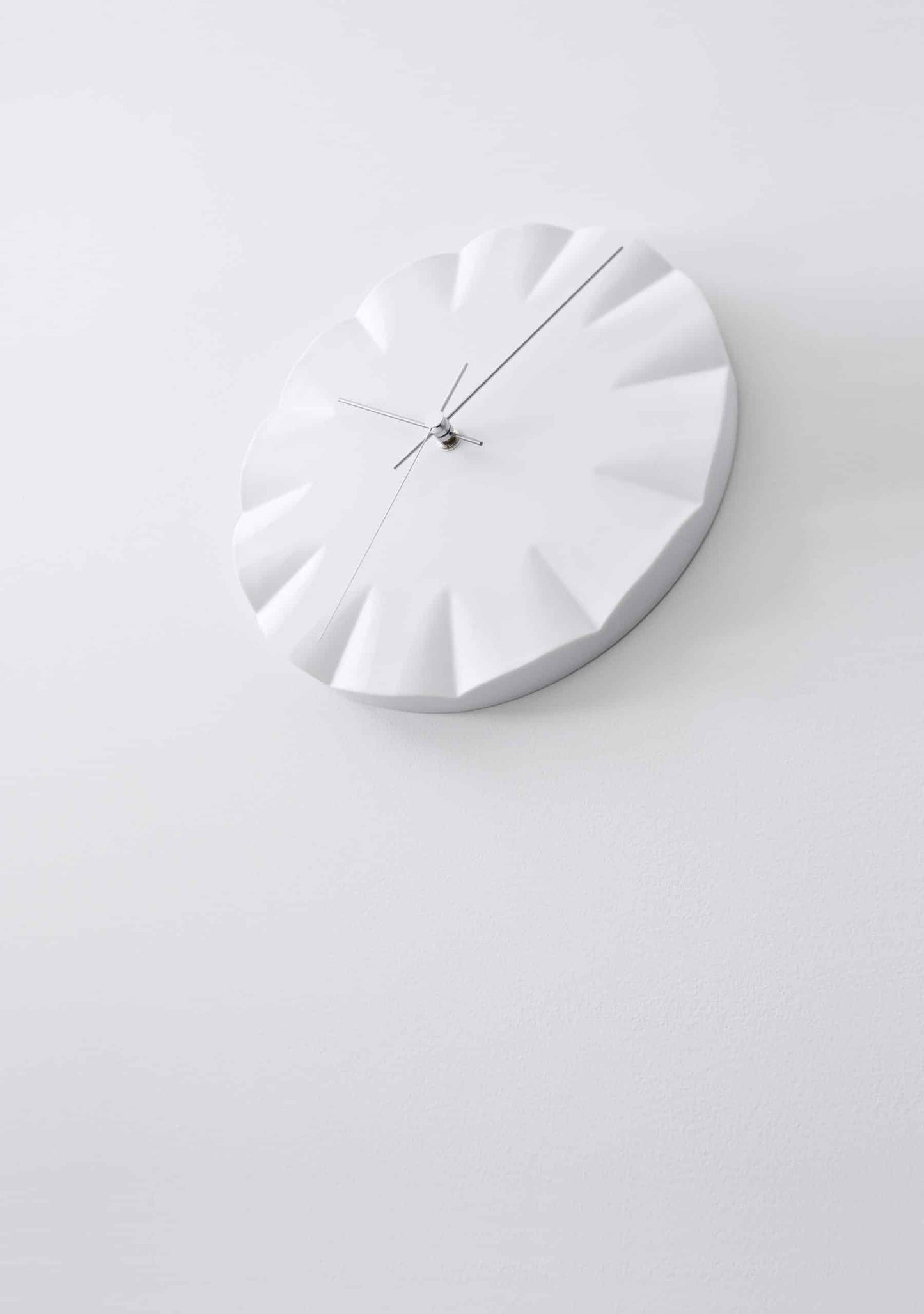 Runde Wanduhr in Weiß mit Relief-Zifferblatt, drei schlanken Zeigern und Mittelachse