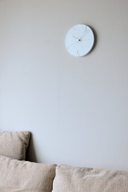 Weiße Porzellan-Wanduhr an der Wand mit schmalen Linien und Uhrzeigern