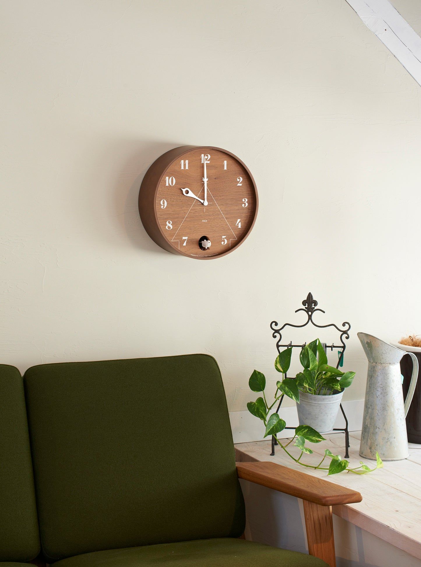 Wandmontierte runde Wanduhr mit braunem Zifferblatt, weißen Ziffern und Zeigern