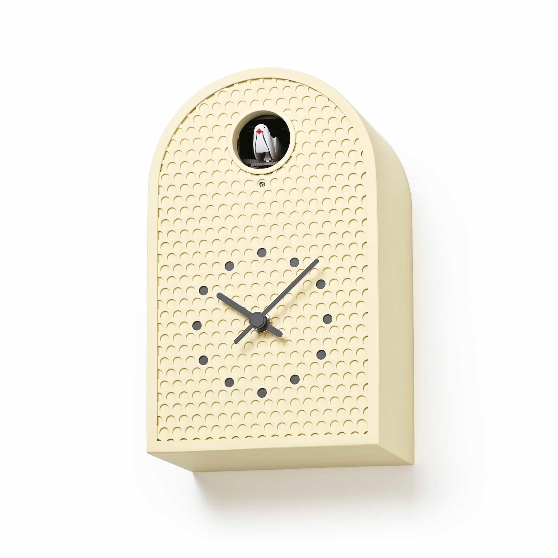 Cremefarbene Wanduhr mit gepunkteter Front, schwarzem Pendelbereich und runden Fenstern