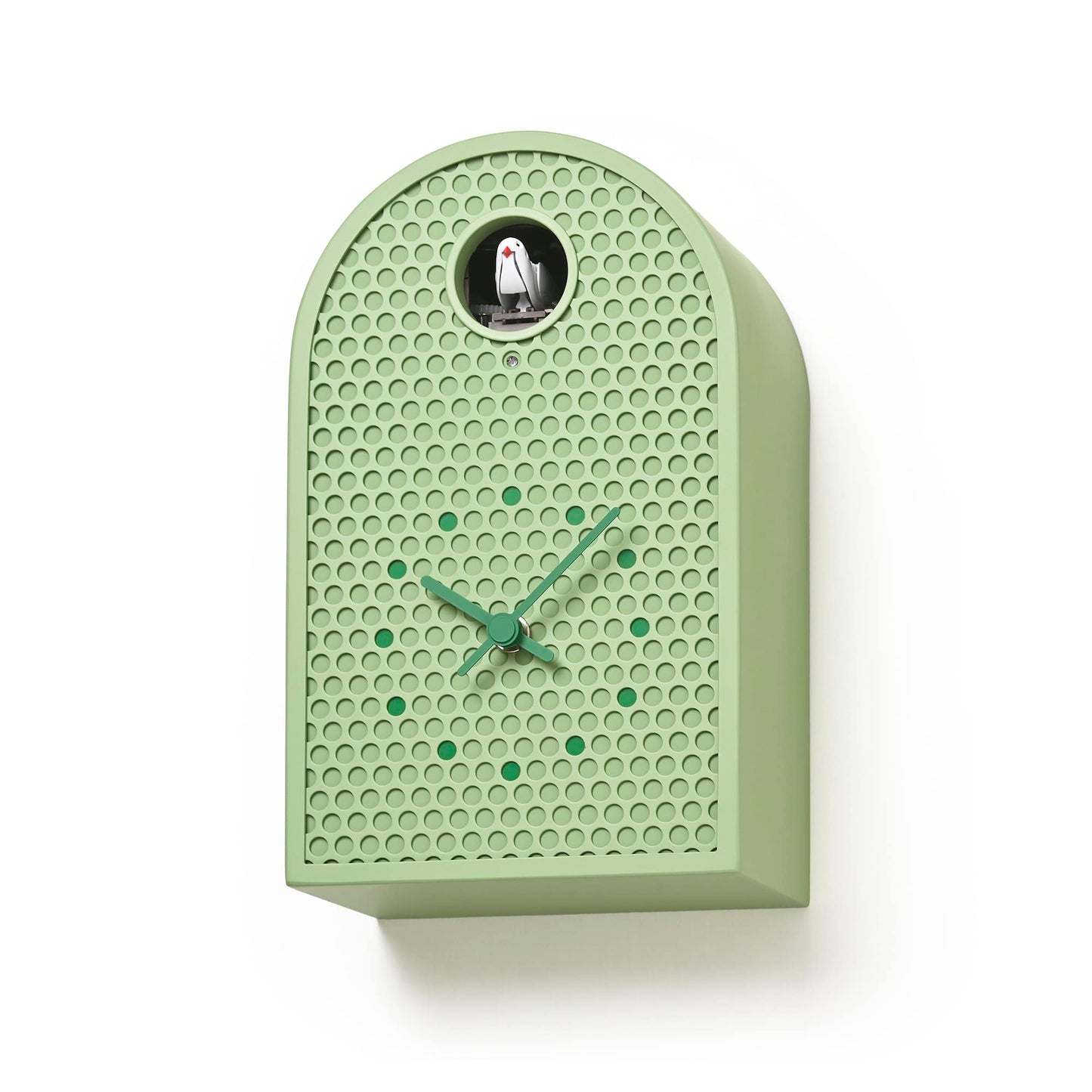 Grüne Wanduhr im Profil mit Relief-Punktemuster und Kuckuckfigur im Rundfenster.