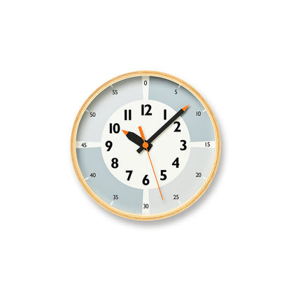 Wanduhr mit beigem Rahmen, grauem Zifferblatt und schwarzen Zeigern mit orangefarbenen Spitzen
