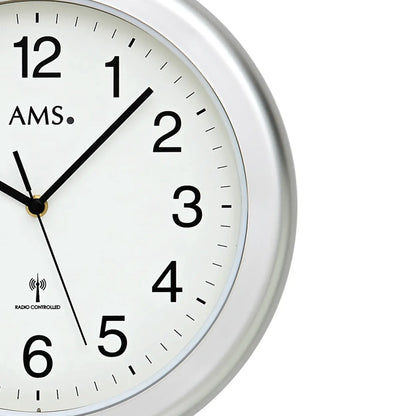Runde Wanduhr mit silbernem Rahmen, weißem Ziffernblatt und schwarzen Zeigern (funkgesteuert)
