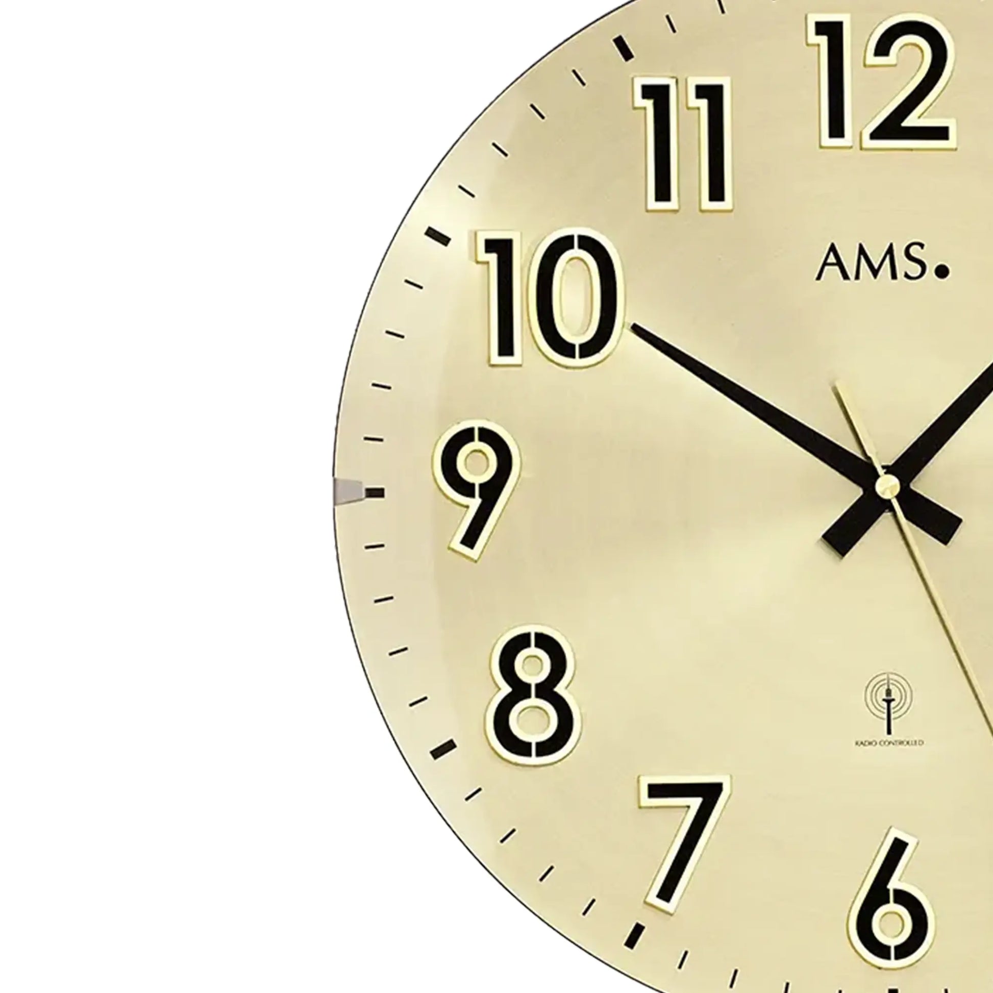 Runde Wanduhr mit goldfarbenem Zifferblatt, schwarzen Zeigern und Ziffern 7–12 im Detail