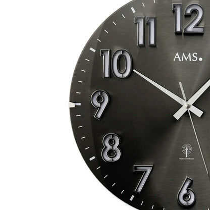 AMS Funk-Wanduhr mit rundem, dunklem Zifferblatt und silbernen Ziffern, Zeiger gut sichtbar