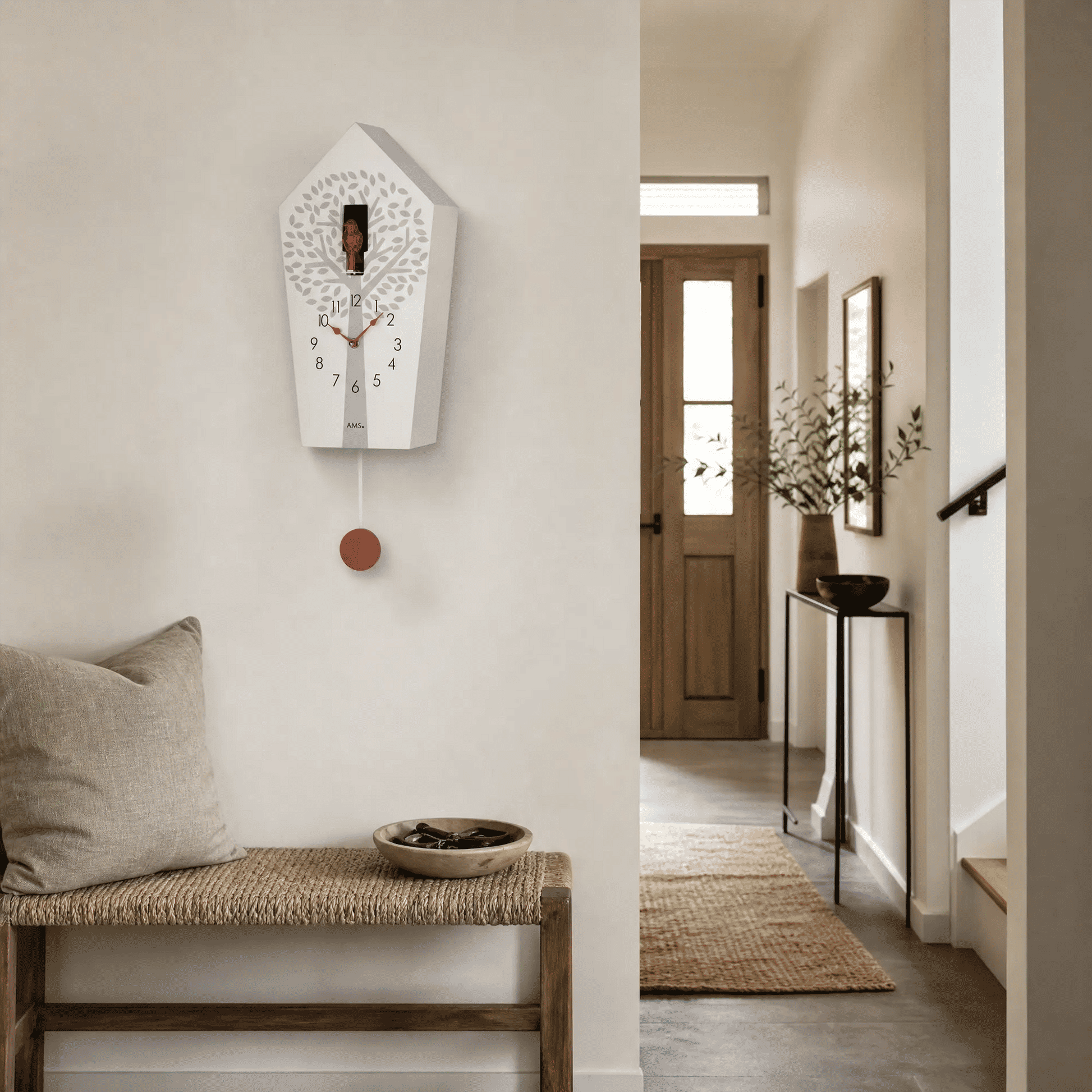 Wanduhr mit weißem Kuckucks-Gehäuse und rotem Pendelknopf an der Wand