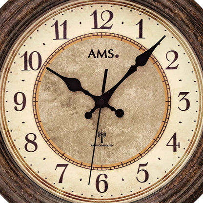 Nahaufnahme: runde AMS Funk-Wanduhr mit antikem Zifferblatt und schwarzen Zeigern