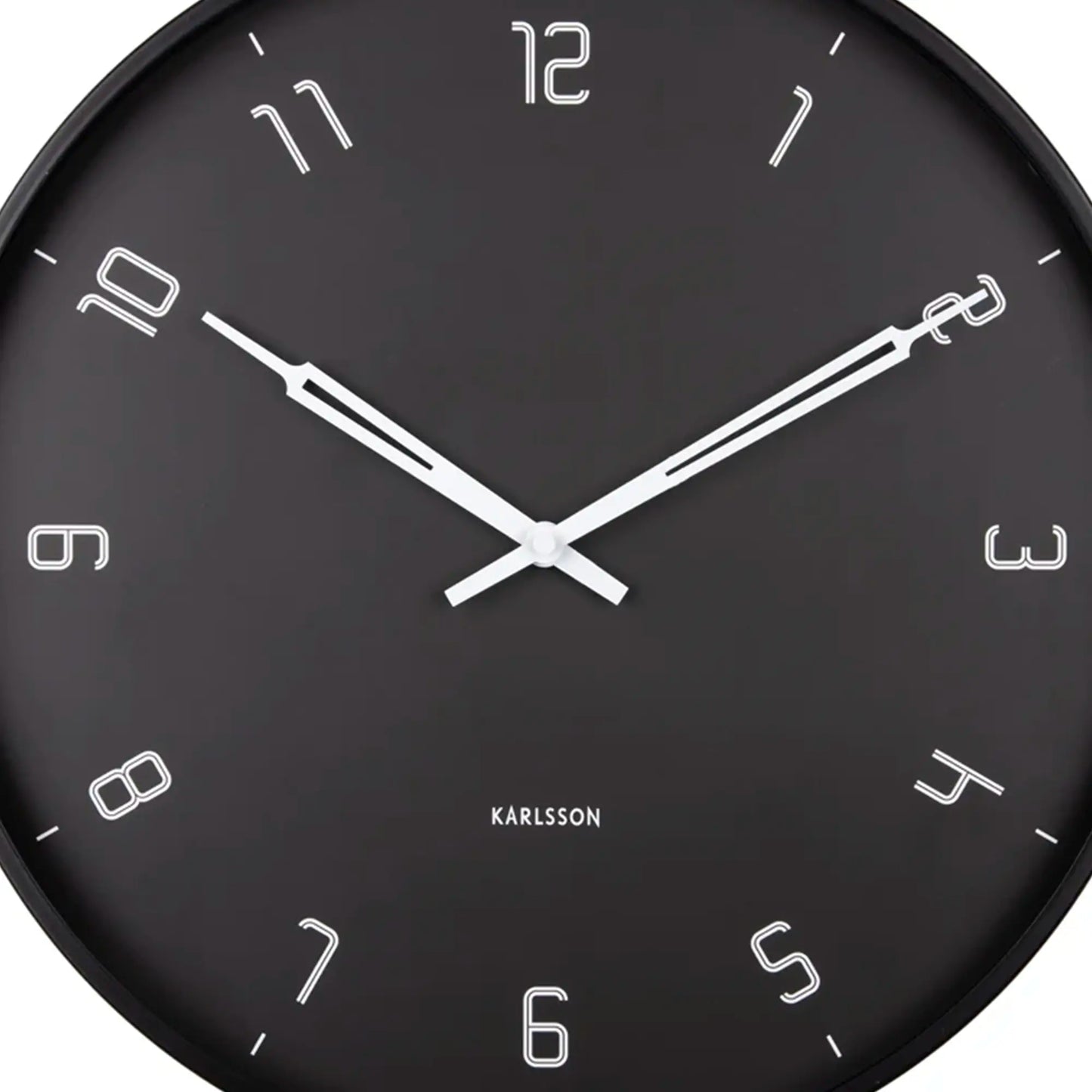 Nahaufnahme: schwarze Wanduhr mit weißen Zeigern und Ziffern, kreisrundes Gehäuse