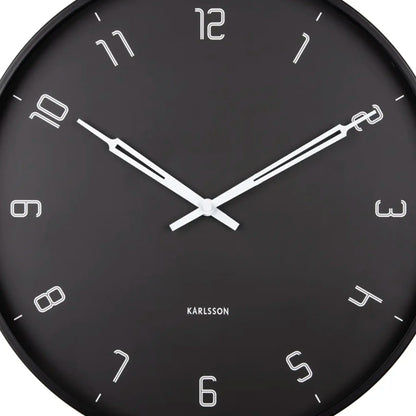 Nahaufnahme: schwarze Wanduhr mit weißen Zeigern und Ziffern, kreisrundes Gehäuse