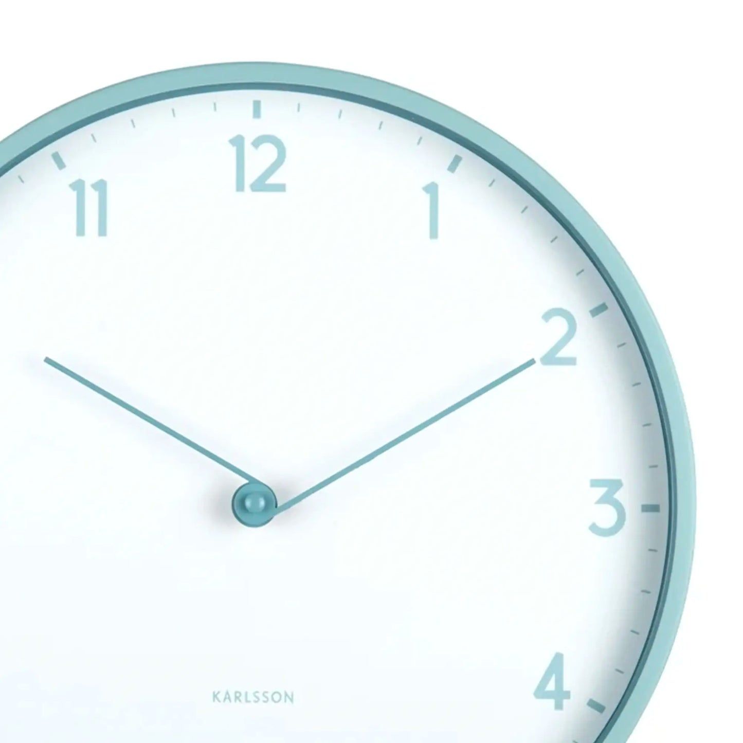Nahaufnahme der Karlsson Wanduhr: hellblauer Rand, weißes Zifferblatt, Zeiger und Ziffern
