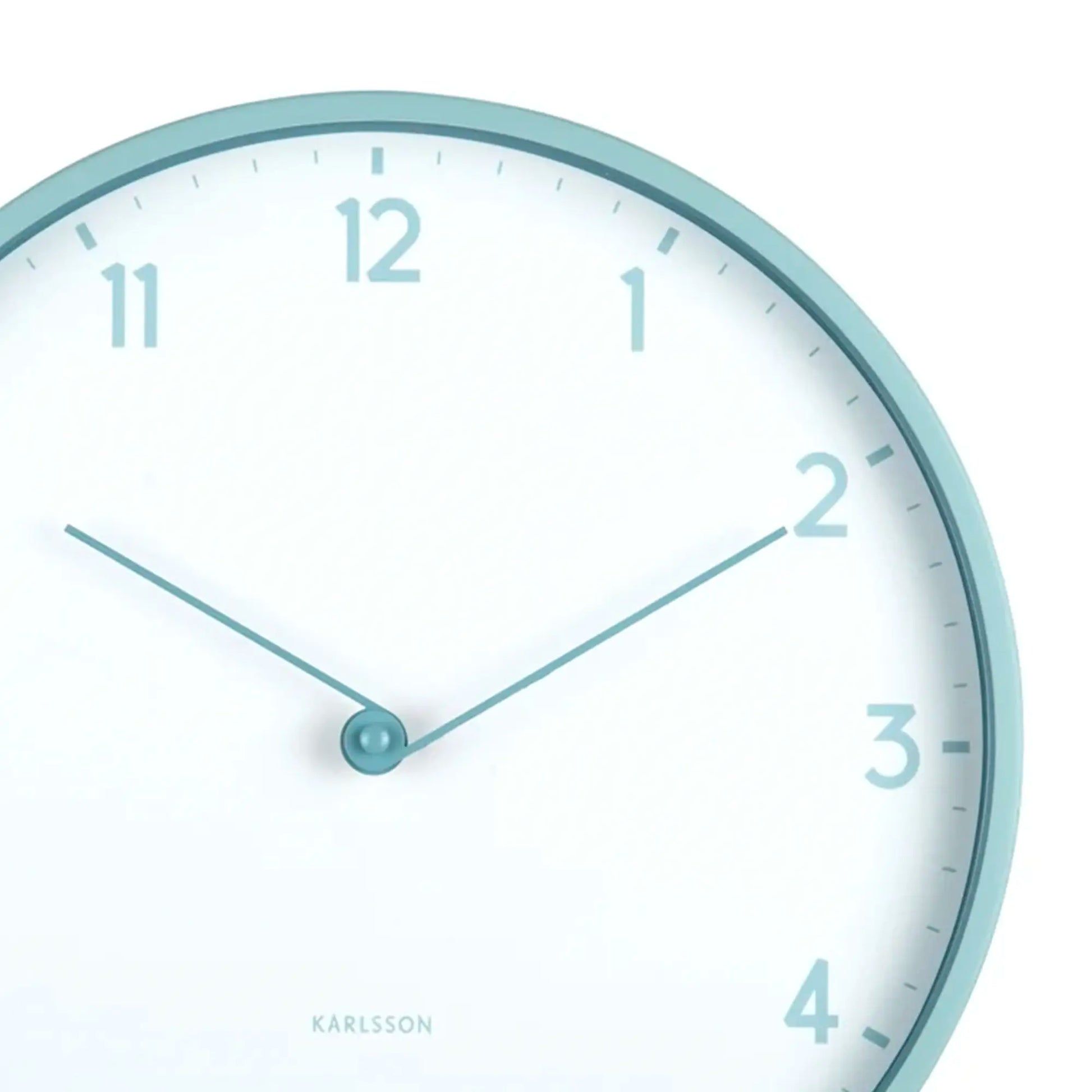 Nahaufnahme der Karlsson Wanduhr: hellblauer Rand, weißes Zifferblatt, Zeiger und Ziffern