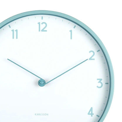 Nahaufnahme der Karlsson Wanduhr: hellblauer Rand, weißes Zifferblatt, Zeiger und Ziffern