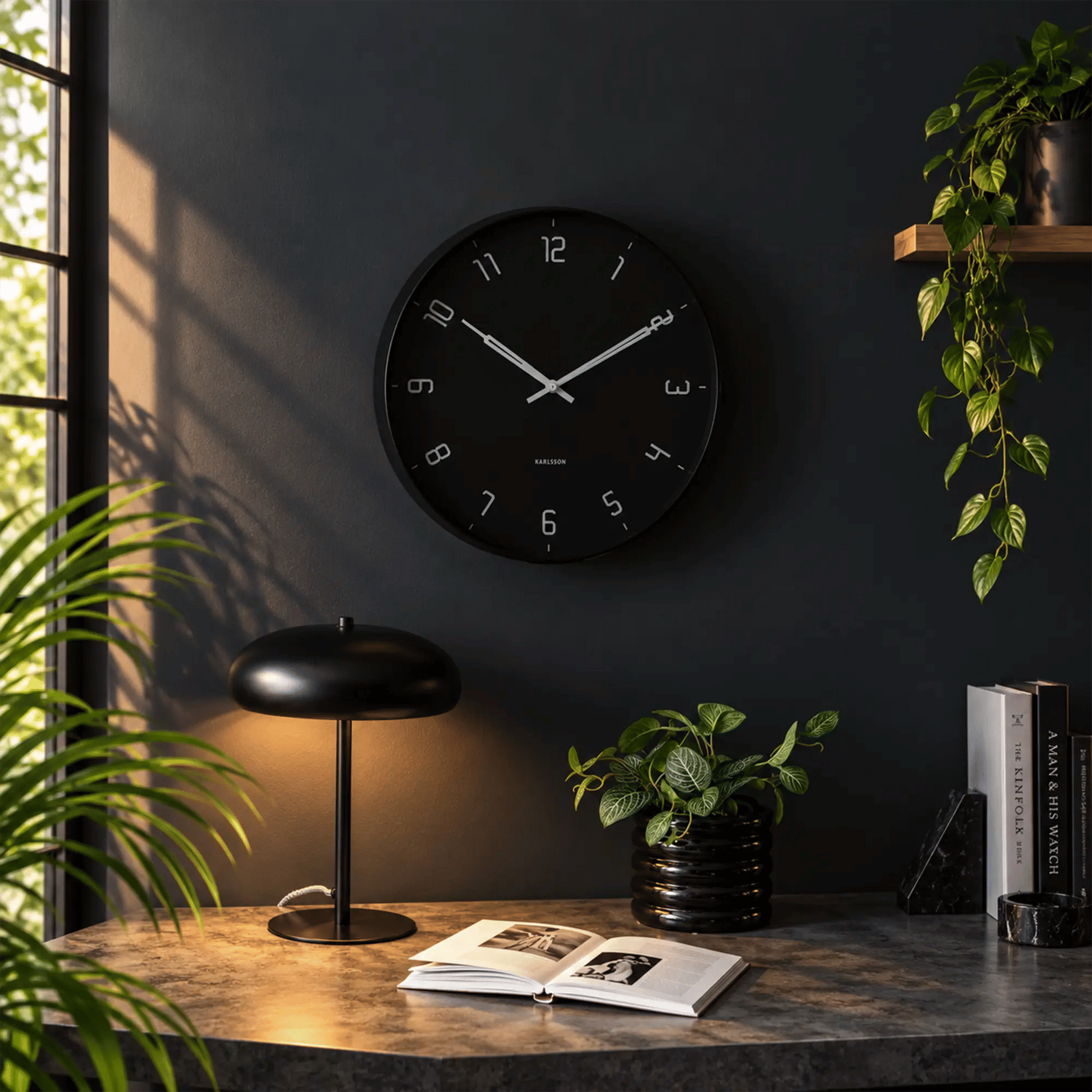 Schwarze runde Wanduhr mit Analoganzeige, weißen Markierungen und Zeigern