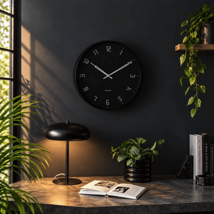 Schwarze runde Wanduhr mit Analoganzeige, weißen Markierungen und Zeigern