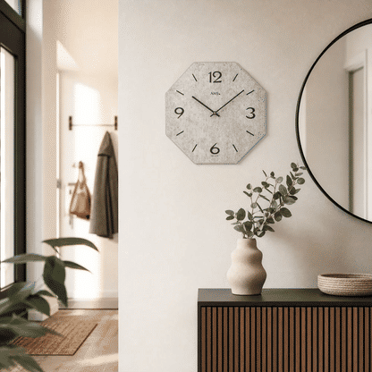 Wall clock on the wall with a gray dial, numbers 3, 6, 9, 12, and hands