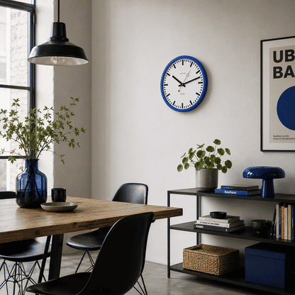 Wanduhr an der Wand mit blauem Rahmen, weißem Ziffernblatt, roten Zeigern und schwarzen Strichmarken
