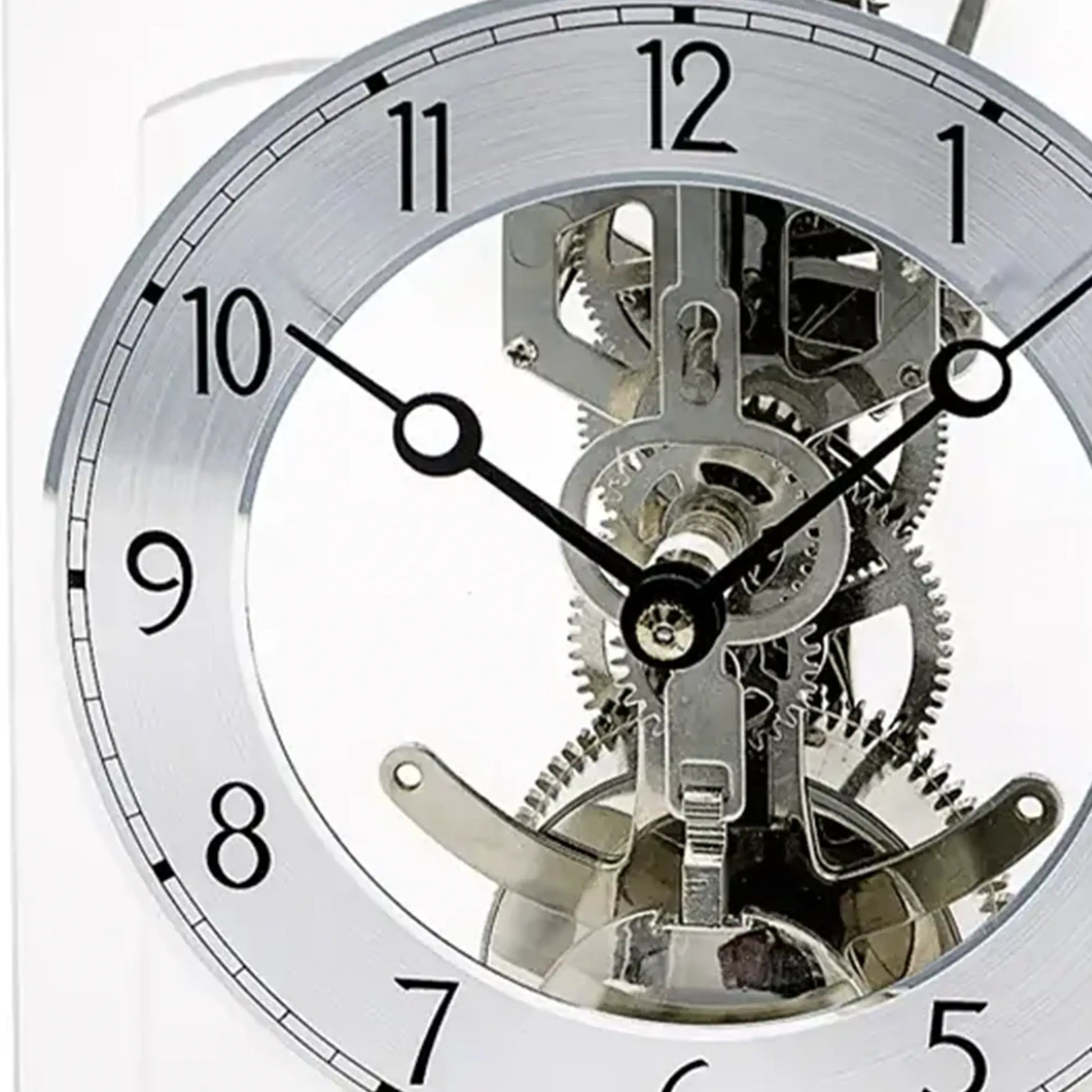 Nahaufnahme der silbernen Tischuhr: Uhrwerk und Zeiger hinter Mineralglas