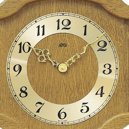 Nahaufnahme: Wanduhr-Ziffernblatt aus Eiche mit goldenen Zeigern und AMS-Logo