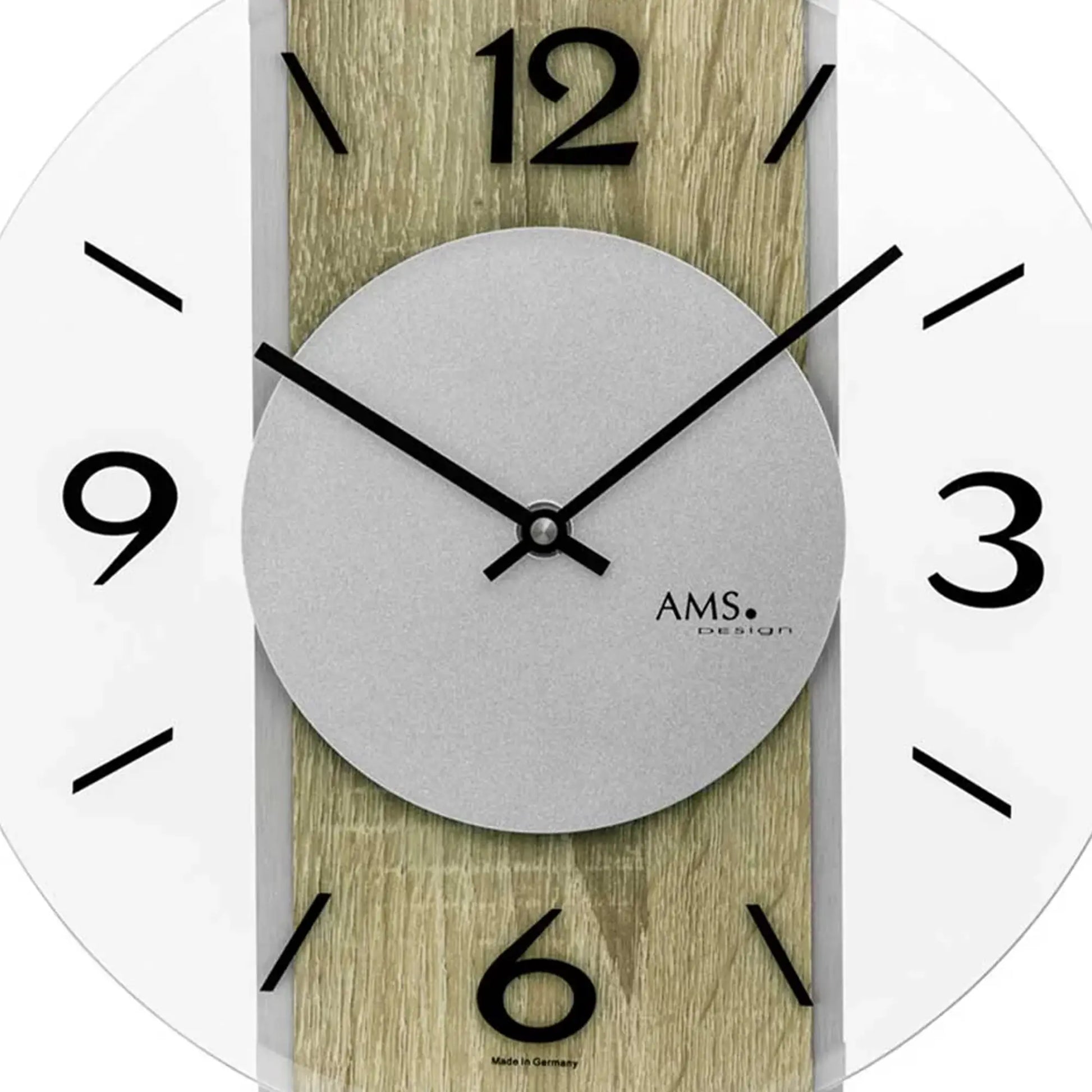 Detail der Wanduhr: hellgraues Zifferblatt, schwarze arabische Zahlen, schwarze Zeiger, AMS-Logo
