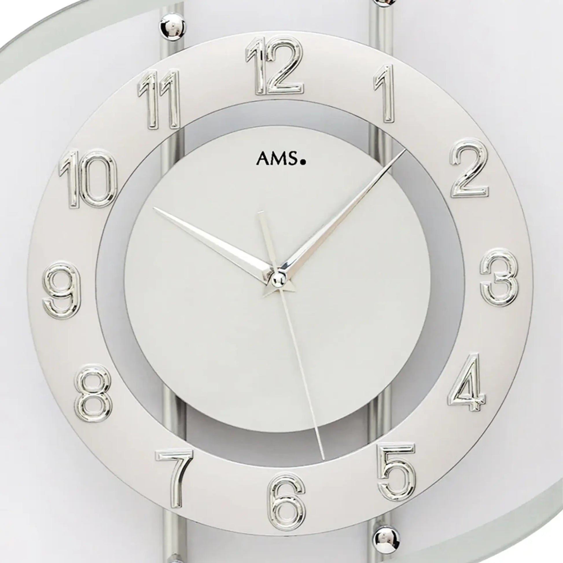 Nahaufnahme: Silberne Funk-Wanduhr mit rundem Ziffernblatt, römischen Zahlen und Zeigern.