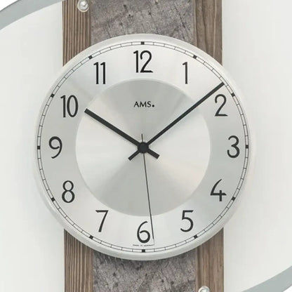 Nahaufnahme Wanduhr: weißes Zifferblatt mit AMS-Schriftzug und schwarzen Zeigern