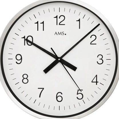 Nahaufnahme: runde Wanduhr mit weißem Zifferblatt, schwarzen Zahlen und Zeigern