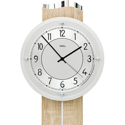 Nahaufnahme Wanduhr: weißes Ziffernblatt, schwarze Zeiger und AMS-Schrift im Glasfenster