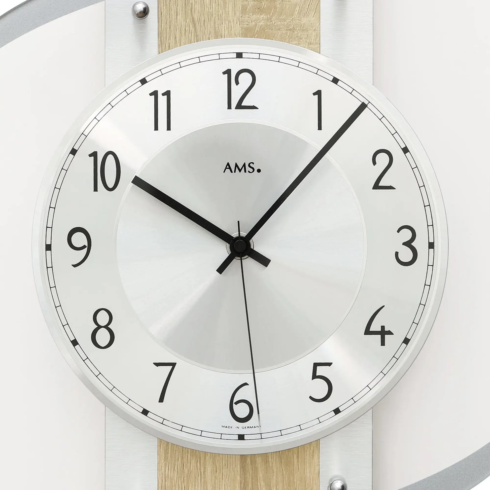 Wanduhr-Zifferblatt: weißer Rundring mit schwarzen Zahlen, AMS-Logo und Zeigern