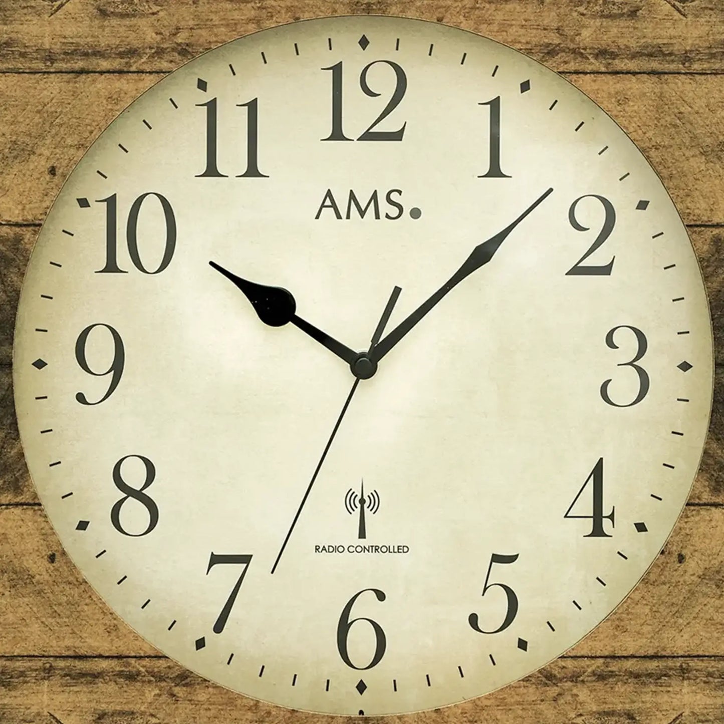 AMS Wanduhr Großaufnahme: beige Zifferblatt, schwarze Zeiger, Funkuhr-Symbol, Holzstruktur