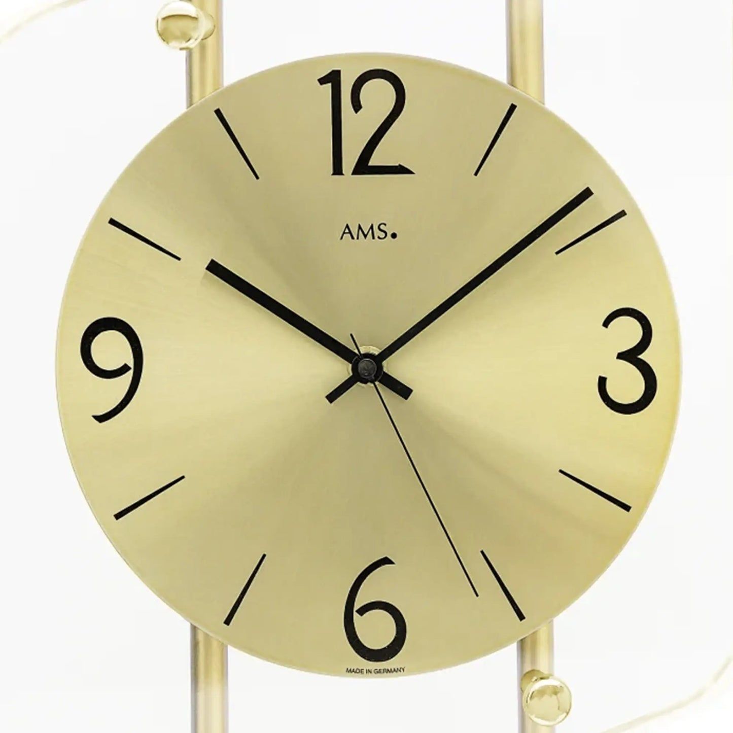 Nahaufnahme AMS Wanduhr: rundes gelbes Ziffernblatt mit Ziffern 12, 9, 3 und Zeigern
