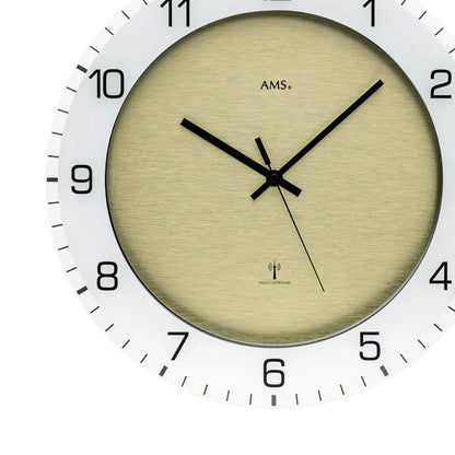 Nahaufnahme: beiges Ziffernblatt einer Wanduhr mit schwarzem Zeigersystem und Zahlen