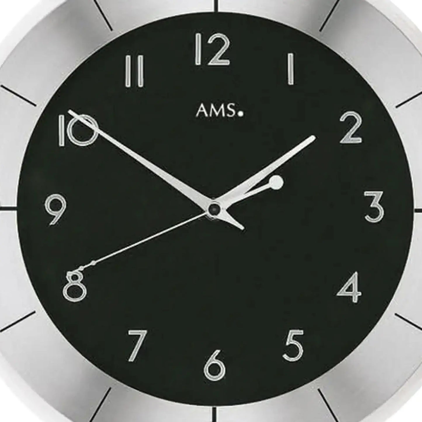 Nahaufnahme: Wanduhr mit schwarzem Ziffernblatt, silbernen Zahlen und Zeigern