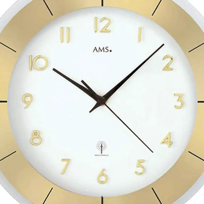 Detail der Wanduhr: weißes Ziffernblatt mit arabischen Ziffern, goldfarbene Fassung