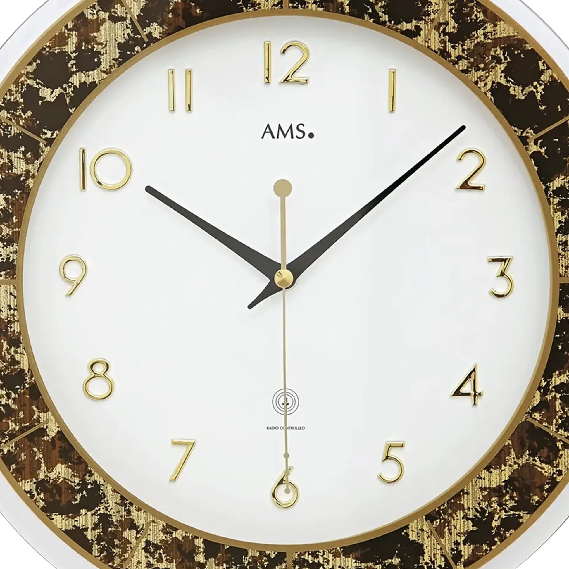 Nahaufnahme Wanduhr: weißes Zifferblatt mit goldenen Zahlen, braun-goldene Innenfassung