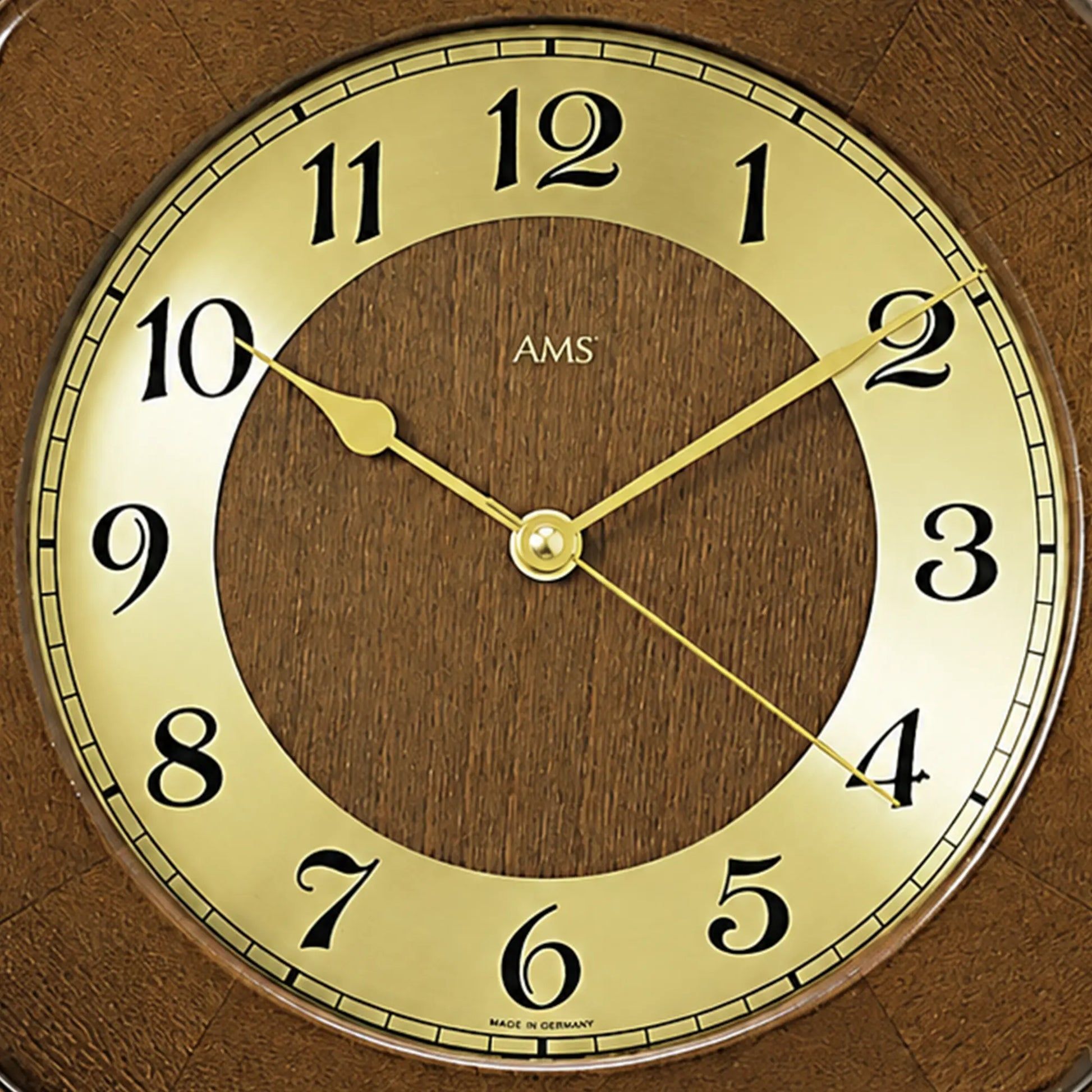 Nahaufnahme: Wanduhr-Ziffernblatt mit gelben Zeigern und Holzoptik im Rahmen