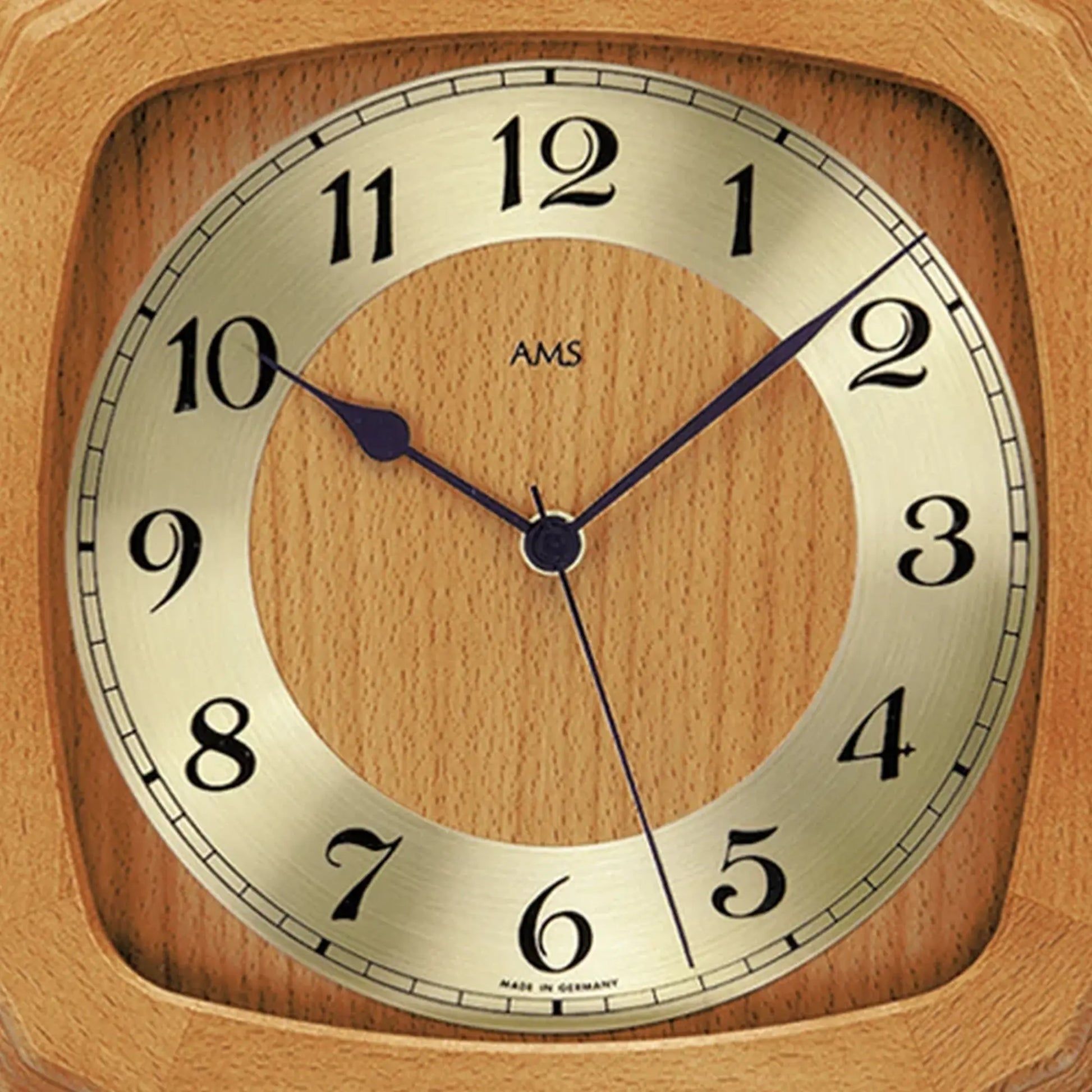 Nahaufnahme Funk-Wanduhr: Holzrahmen, Ziffernblatt mit AMS-Logo und Zeigern